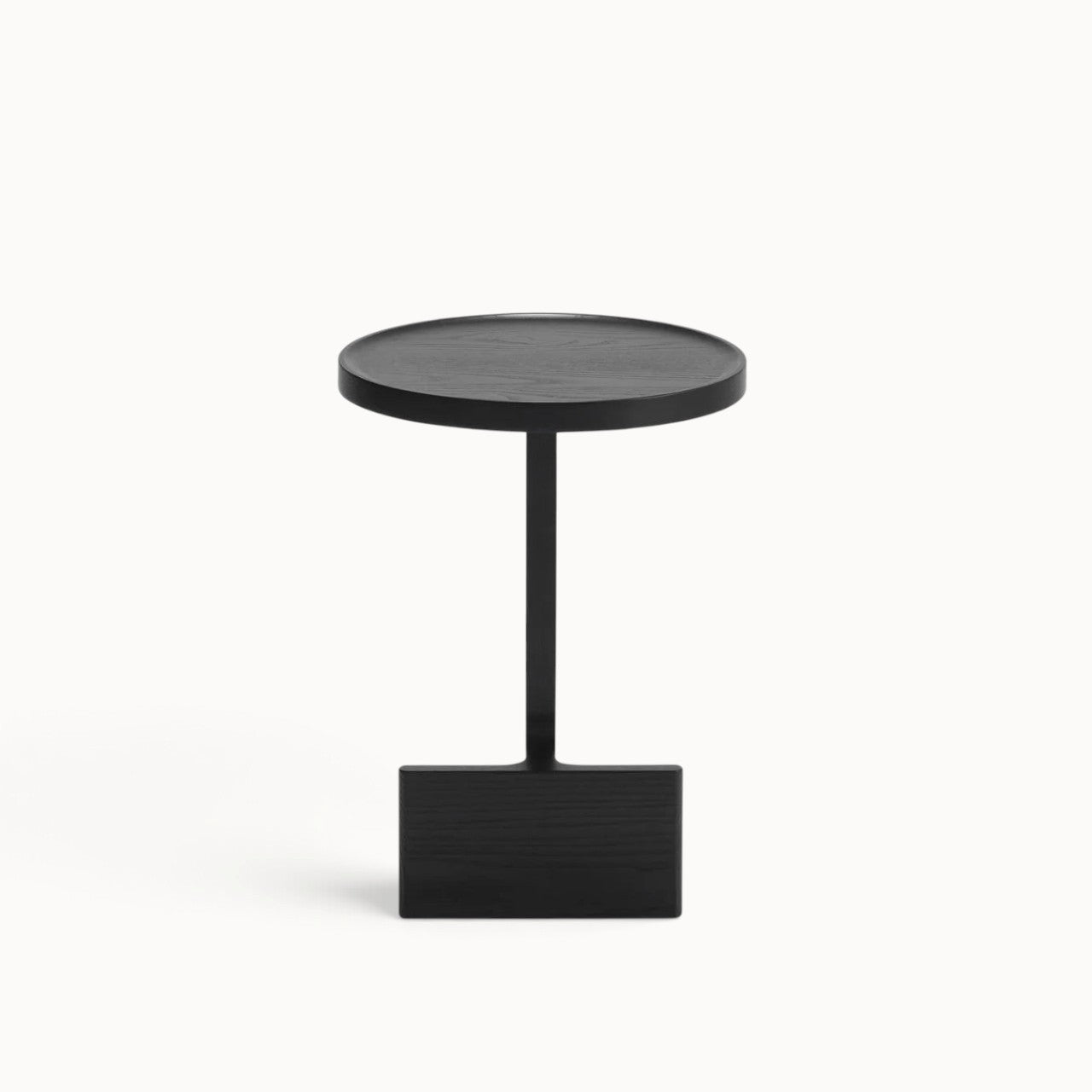 hibino Beam side table in black wood with a sculptural pedestal base and round tabletop on a white background