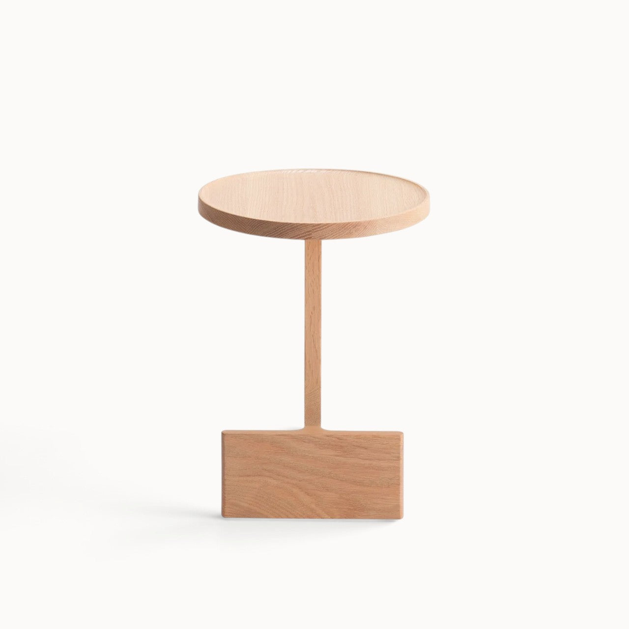hibino Beam side table in light oak wood with a sculptural, minimalist design and a circular tabletop.