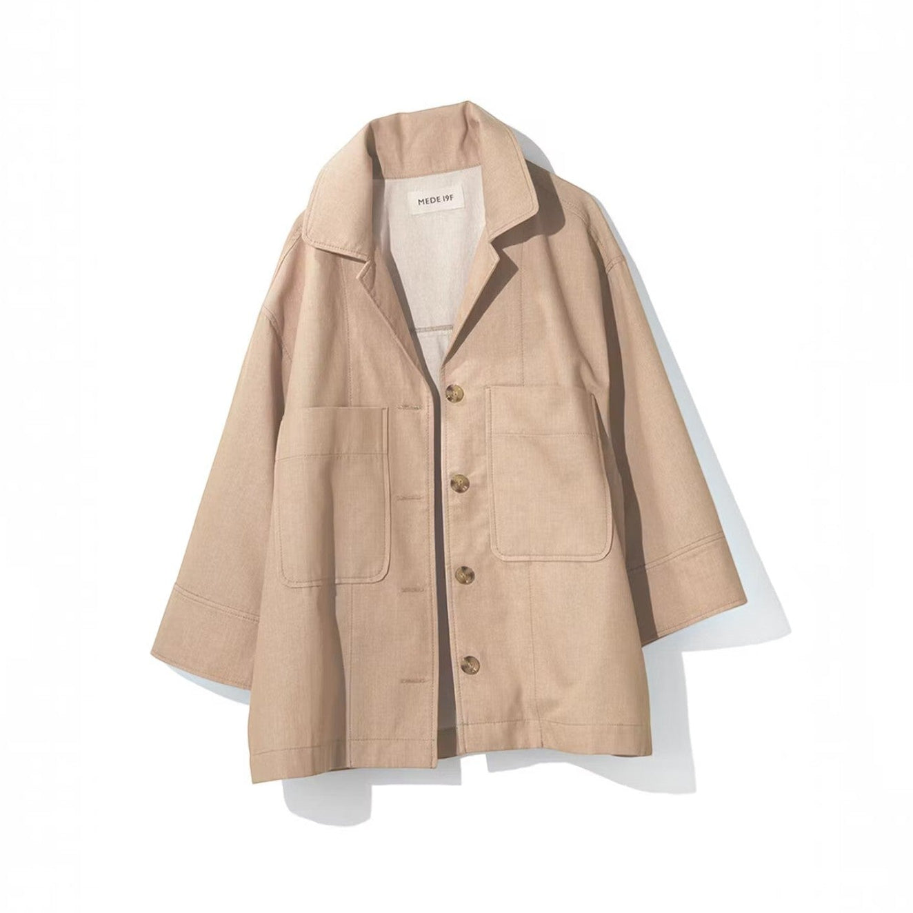 hibino beige cotton shirt jacket with wide sleeves, collar, and two front pockets on a white background