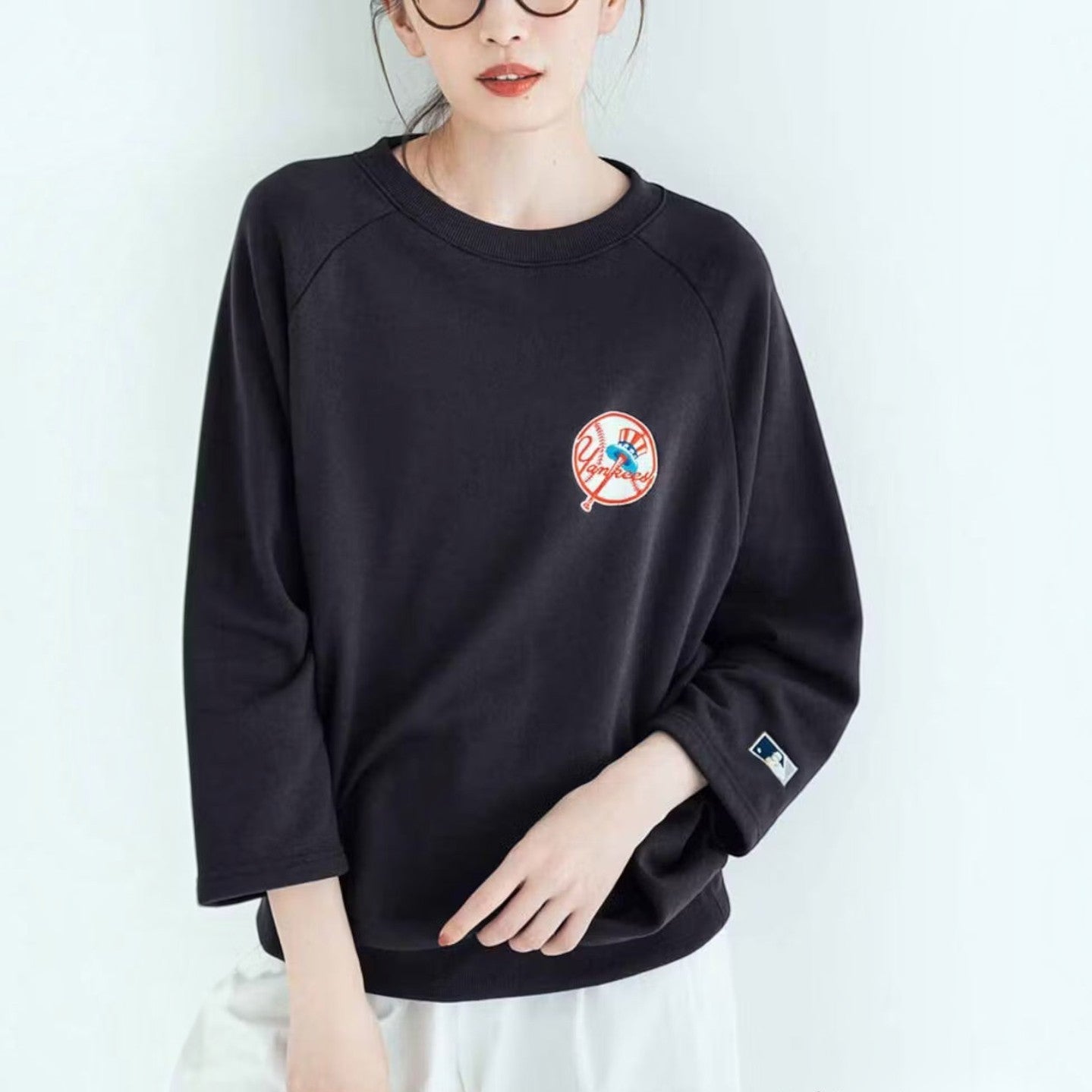 hibino charcoal black New York Yankees Cooperstown Collection sweatshirt with three-quarter sleeves on a woman